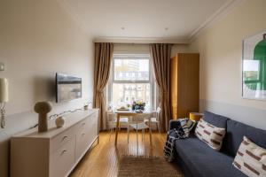 ロンドンにあるThe Courtfield - Serviced Apartmentsのリビングルーム(青いソファ、テーブル付)