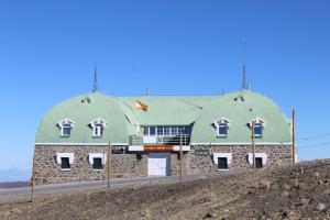 um edifício com um telhado verde no topo de uma colina em Esquí y Relax Apartamento em Sierra Nevada