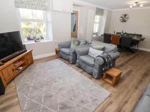 a living room with two couches and a flat screen tv at Golygfa Bryn in Porth