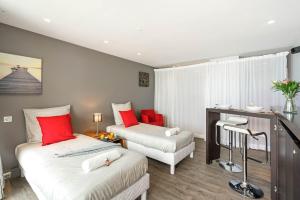 Dos camas en una habitación con rojo y blanco. en Biarritz - Residence Victoria surf - Face océan, en Biarritz