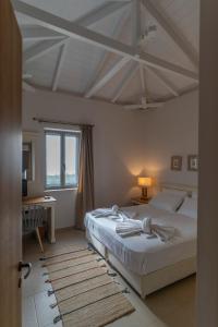 a bedroom with a large bed and a window at Mythos Villas in Stoupa
