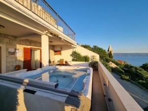 una vasca idromassaggio sul balcone di una casa di Villa Tonka with jacuzzi a Podstrana