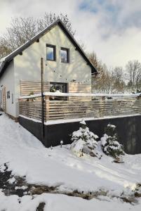 ein Haus ist mit Schnee bedeckt mit Schneemessern in der Unterkunft Chata Fraluq in Tatobity