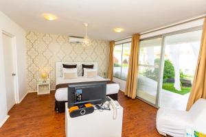 Hotel Del Mar Mancora في مانكورا: غرفة نوم فيها سرير وتلفزيون