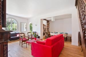 a living room with a red couch and a table at Bidart - Uhabia plage - Maison familiale in Bidart