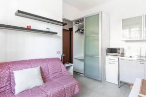een woonkamer met een roze bank en een keuken bij enJoy Home - Piccolo monolocale zona Ospedale in Padua
