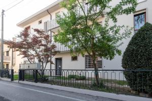 een wit gebouw met een hek ervoor bij enJoy Home - Piccolo monolocale zona Ospedale in Padua