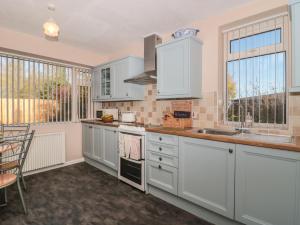 a kitchen with white cabinets and a counter top at Coronation Cottages No 2 in Weston-super-Mare
