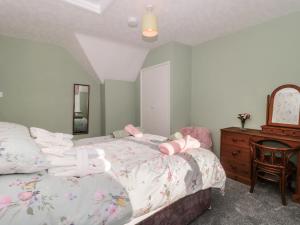 een slaapkamer met een bed, een dressoir en een spiegel bij Coronation Cottages No 2 in Weston-super-Mare