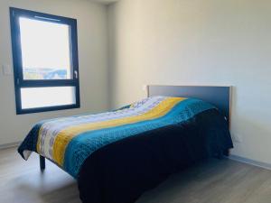 a bedroom with a bed with a colorful blanket on it at Résidence Services Séniors in Montignac