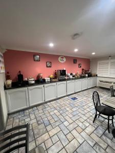 a kitchen with pink walls and a table and chairs at Super 8 by Wyndham McAllen-Downtown-Airport-LA Plaza Mall in McAllen