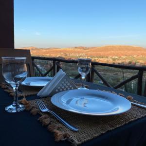 a table with two plates and wine glasses on it at Panorama Complex in Tahannout