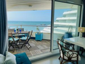 een kamer met een balkon met een tafel en stoelen bij Biarritz - Le Miramar - Studio face ocean in Biarritz