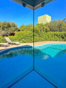 uma vista para uma piscina a partir do exterior de uma casa em Rancho Litoral Búzios em Búzios