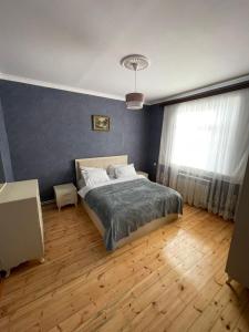 een slaapkamer met een bed en een groot raam bij Resulzade Villa in Baku