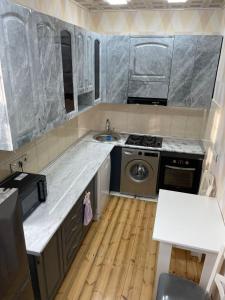 een keuken met een spoelbak en een wasmachine bij Resulzade Villa in Baku