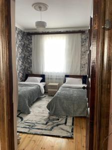 twee bedden in een kamer met een raam bij Resulzade Villa in Baku +3 foto's