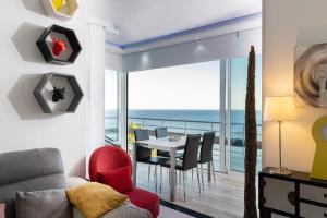 - un salon avec une table à manger et une vue sur l'océan dans l'établissement La Torre De La Roca, à Torremolinos