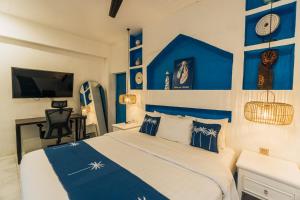 ein blau-weißes Schlafzimmer mit einem Bett und einem TV in der Unterkunft APS House Pererenan in Canggu