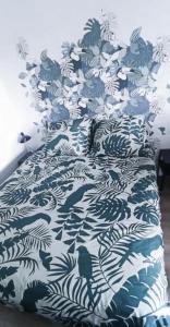 a bed with a blue and white bedspread with fish on it at L'appart de la Vallée-aux-loups by Beds4Wanderlust in Châtenay-Malabry