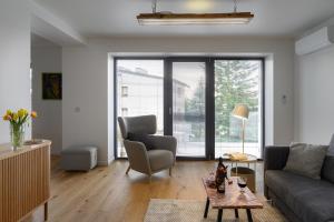 a living room with a couch and a table at LUBLIN RESIDENCE Butikowe apartamenty, zamknięty parking, ogród, 2x klimatyzacja, ekspres z młynkiem, prywatne wejście in Lublin