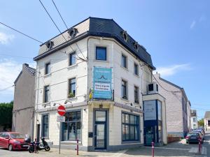 a white building on the corner of a street at A Fleur de Couette in Auvelais