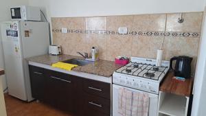 Una cocina con una estufa blanca y un fregadero. en MG ESQUEL, en Esquel
