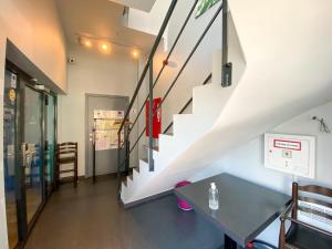 a room with a staircase and a table at A Fleur de Couette in Auvelais