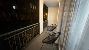two chairs sitting on a balcony at night at Alexia Flat in Sibiu