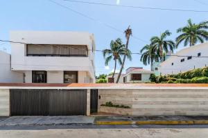 a white house with palm trees in the background at Beautiful Big House on a great strategic location in Cancún