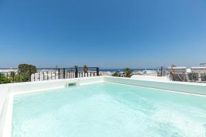 una grande piscina con vista sull'oceano di Nostos Apartments Kamari a Kamari