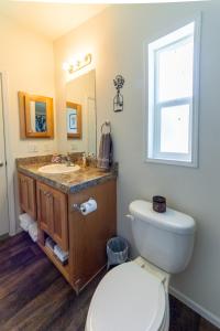 a bathroom with a toilet and a sink and a window at Cute and Cozy 3 Bed 2 Bath Home in North Spokane in Spokane