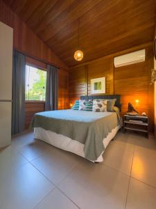 a bedroom with a bed in a room with wooden walls at Rancho Litoral Búzios in Búzios