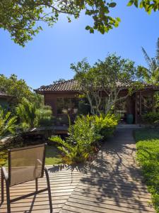 a bench on a wooden walkway in front of a house at Rancho Litoral Búzios in Búzios