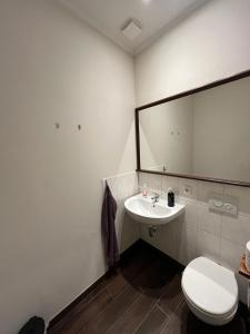 a bathroom with a white toilet and a sink at Turmklause in Luckenwalde