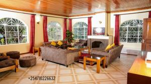 ein Wohnzimmer mit Sofas und einem Kamin in der Unterkunft Naivasha TownHouse in Naivasha