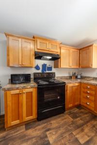 a kitchen with wooden cabinets and a black stove at Cute and Cozy 3 Bed 2 Bath Home in North Spokane in Spokane