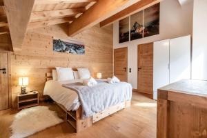 een slaapkamer met een bed en een houten muur bij Terra Losa 2 - Quiet and modern apartment - City center in Les Houches
