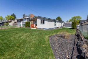 a yard with a fence in front of a house at Cute and Cozy 3 Bed 2 Bath Home in North Spokane in Spokane