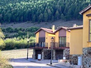ein gelbes Haus mit einem Balkon und einem Berg in der Unterkunft Alojamiento Rural El Morenal in Tragacete