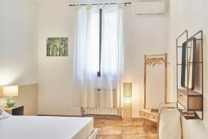 Habitación blanca con cama y ventana en La Limonaia Country House en Siena