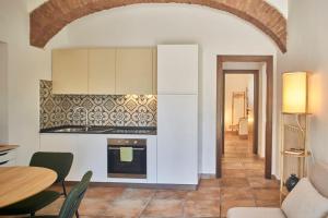 sala de estar con mesa y cocina en La Limonaia Country House en Siena
