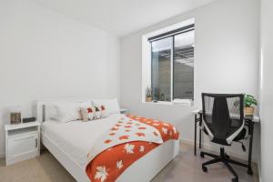 1 dormitorio con cama, escritorio y silla en Luxurious & Stylish 2BR P/Suite, Near Vancouver en Langley