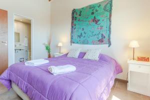 a purple bed with two towels on top of it at Beautiful Apartment Downtown, Amazing Lake Views JF1 by Apartments Bariloche in San Carlos de Bariloche