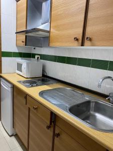 a kitchen with a sink and a microwave at Apartaments Crest Pas in Pas de la Casa