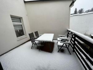 balcón con mesa y sillas cubiertas de nieve en Apartment Conan, en Auerbach