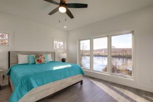 a bedroom with a bed and a large window at Bright Cotter Vacation Rental with White River Views in Cotter