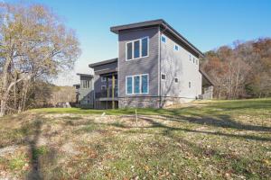 a house on a hill with a grassy field at Bright Cotter Vacation Rental with White River Views in Cotter