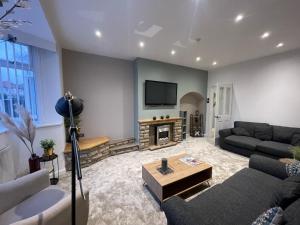 uma sala de estar com um sofá e uma lareira em Modern Spacious 5 Bed House in Newcastle em Newcastle upon Tyne