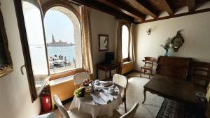 威尼斯的住宿－聖錫米恩公寓，一间配备有桌子的用餐室,享有水景
